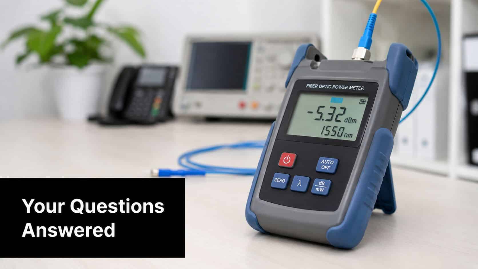 A handheld fiber optic power meter displaying a measurement reading on a clean office desk workspace.