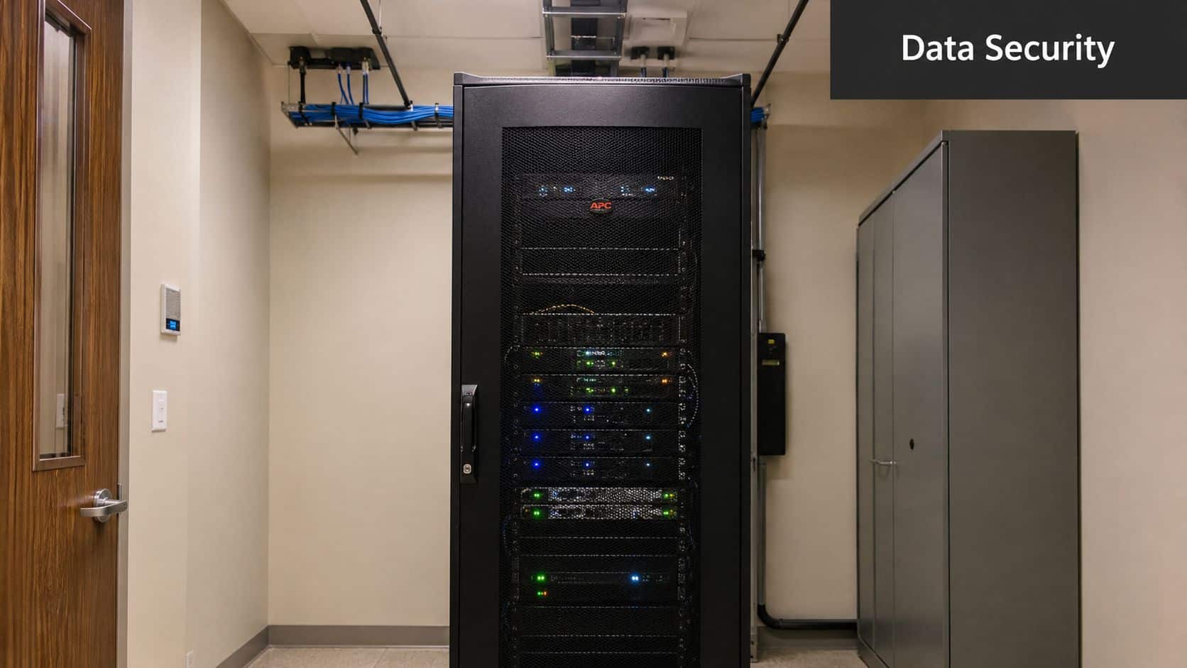 A secure server room featuring a black network server cabinet and an adjacent grey storage cabinet.