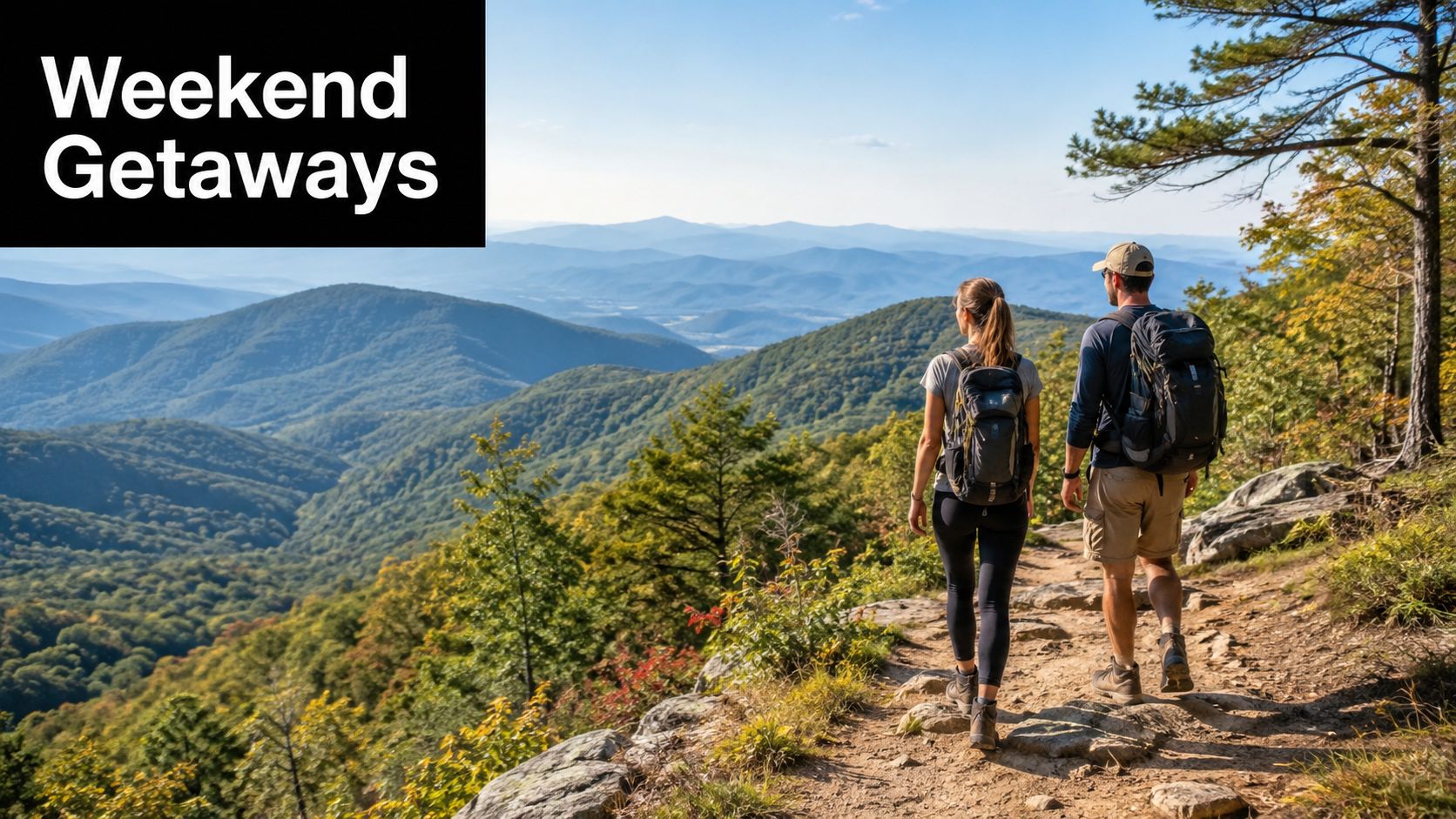 A couple wearing hiking backpacks walking on a scenic mountain trail overlooking a vast green valley.