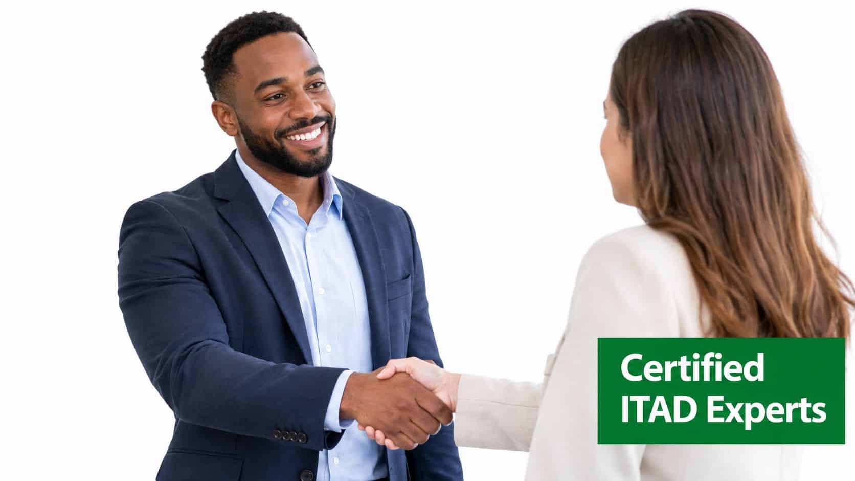 A professional man and woman in business attire shaking hands during a meeting, representing ITAD services.